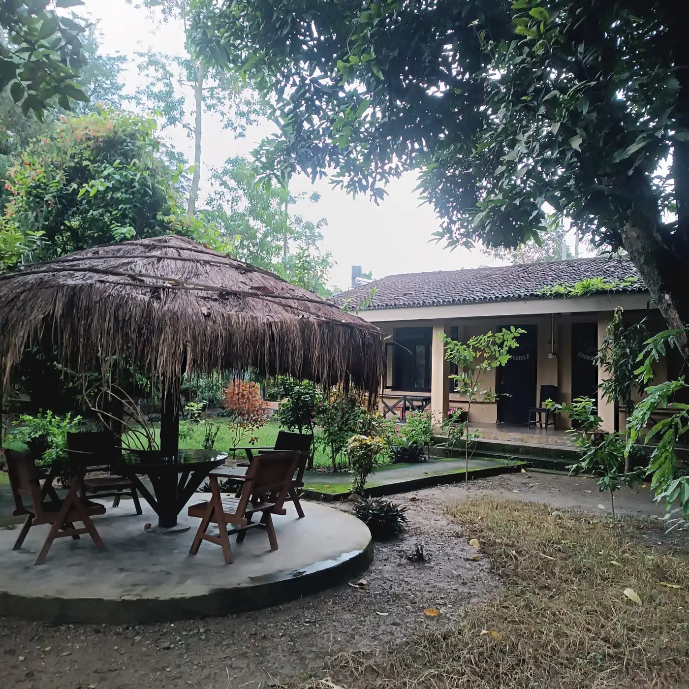 Thatched social area with a table and chairs in the garden