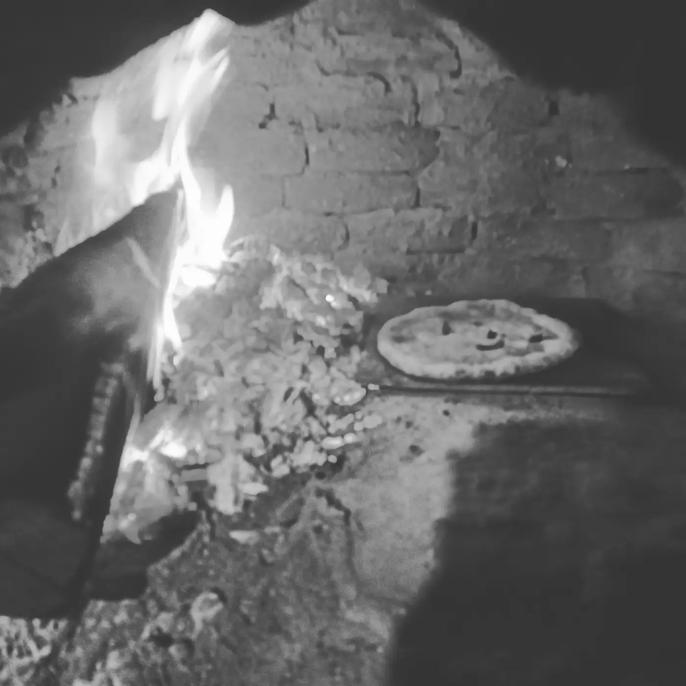 Pizza cooking in a wood-fired oven at Tharu Lodge